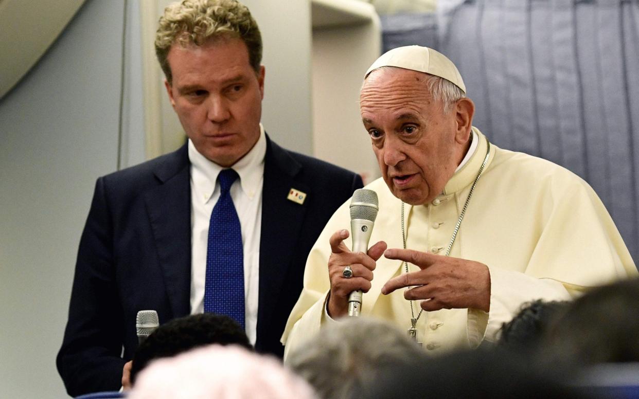 Greg Burke, chief Vatican spokesman, with Pope Francis aboard the papal plane as they returned from a trip to Chile and Peru, 2018 - AFP