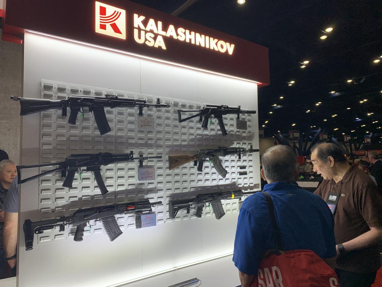 People look at semi-automatic guns at the Kalashnikov booth inside of the National Rifle Association Annual Meeting at the George R. Brown Convention Center, on May 27, 2022, in Houston, Texas. (Photo by STRINGER / AFP) (Photo by STRINGER/AFP via Getty Images)