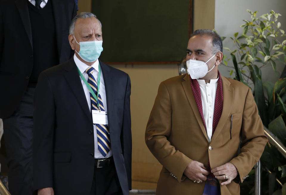 Ramesh Kumar, right, a lawmaker and a leader in the Hindu community and Shoaib Suddle, head of a Commission for Minorities Rights, leave the Supreme Court after a hearing in the case of a Hindu temple that was vandalized, in Islamabad, Pakistan, Tuesday, Jan. 5, 2021. The Supreme Court ordered authorities Tuesday to rebuild the century-old Hindu temple that was vandalized and set on fire by a mob last week, drawing condemnation from the government and leaders of minority Hindus. (AP Photo/Anjum Naveed)