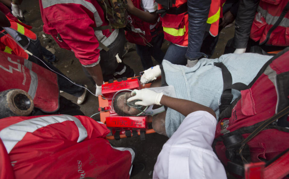 <p>Elizabeth Night Odhiambo is carried away in a stretcher by medics as she is rescued after being trapped for six days in the rubble of a collapsed building in the Huruma section of Nairobi, Kenya, May 5, 2016. After discovering the woman conscious, rescuers administered an IV and oxygen, but then spent several hours freeing her from the rubble. Tragically, after she was brought to the hospital, Odhiambo underwent an emergency cesarean section, but doctors found that her baby had died in the womb. <i>(Photo: Ben Curtis/AP)</i></p>