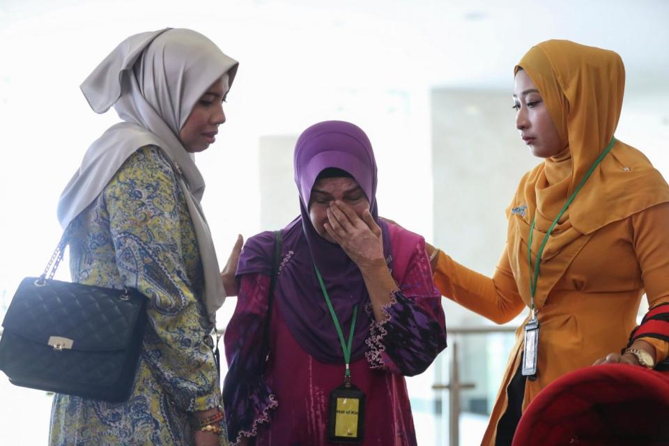 Sarah Nor (C), the mother of Norliakmar Hamid, a passenger on missing Malaysia Airlines flight MH370 at the Ministry of Transport headquarters in Putrajaya, Malaysia (EPA)