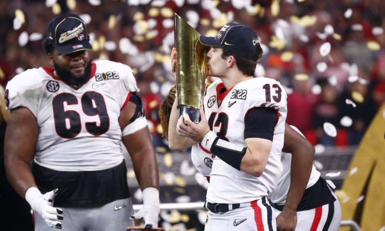 Georgia quarterback Stetson Bennett kisses the CFP trophy.