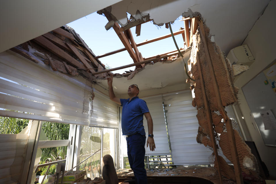 A man looks at the damage to a house in Sderot, Israel, after it was hit by a rocket fired from Gaza Strip, Tuesday, Nov. 12m 2019. Israel has killed a senior Islamic Jihad commander in Gaza in a rare targeted killing that threatened to unleash a fierce round of cross-border violence with Palestinian militants. (AP Photo/Tsafrir Abayov)