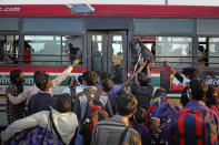 In this Saturday, March 28, 2020, photo, an Indian migrant worker tries to make his way through a window of a bus provided by the government, as they leave for their respective villages following a lockdown amid concern over spread of coronavirus in New Delhi, India. Over the past week, India’s migrant workers - the mainstay of the country’s labor force - spilled out of big cities that have been shuttered due to the coronavirus and returned to their villages, sparking fears that the virus could spread to the countryside. It was an exodus unlike anything seen in India since the 1947 Partition, when British colothe subcontinent, with the 21-day lockdown leaving millions of migrants with no choice but to return to their home villages. (AP Photo/Altaf Qadri)