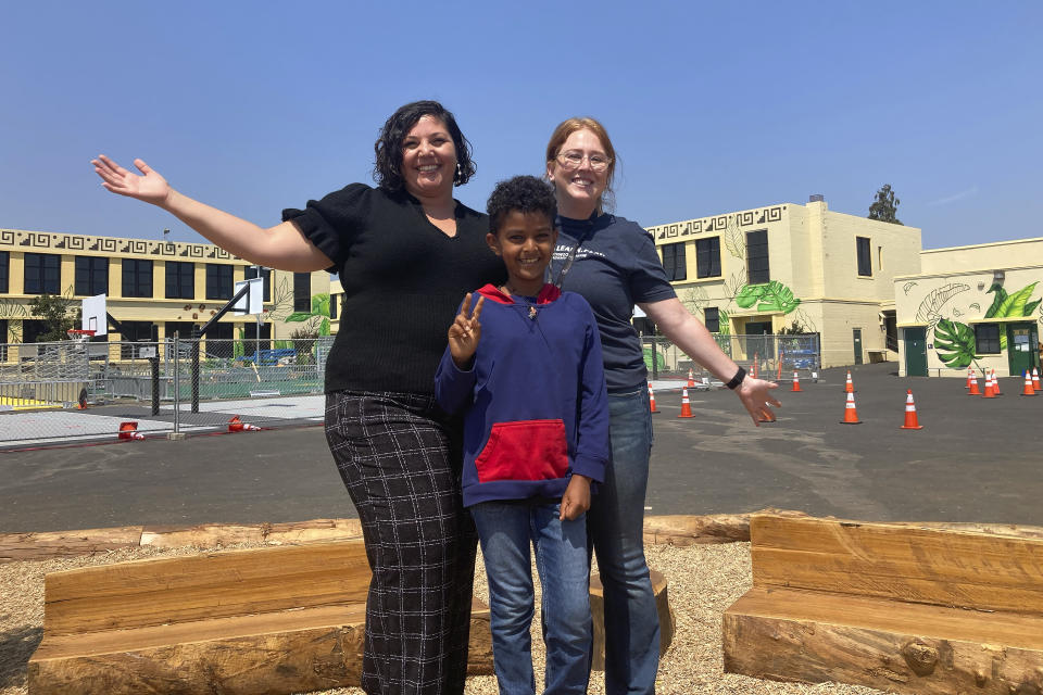 Lockwood STEAM Academy principal Nehseem Ratchford, left, poses for photos in the school's yard with fourth-grader Ermias Afeworki, middle, and Rose Chardak, the school's Community School Manager, in Oakland, Calif., Thursday, Aug. 31, 2023. The family of Stephen Curry and partners are expanding the reach of their Eat.Learn.Play. Foundation, established in 2019 to support youth in Oakland, the Bay Area and beyond, while striving to improve lives of families nationwide. They are generating $50 million in additional funding to assist the Oakland Unified School District. (AP Photo/Janie McCauley)