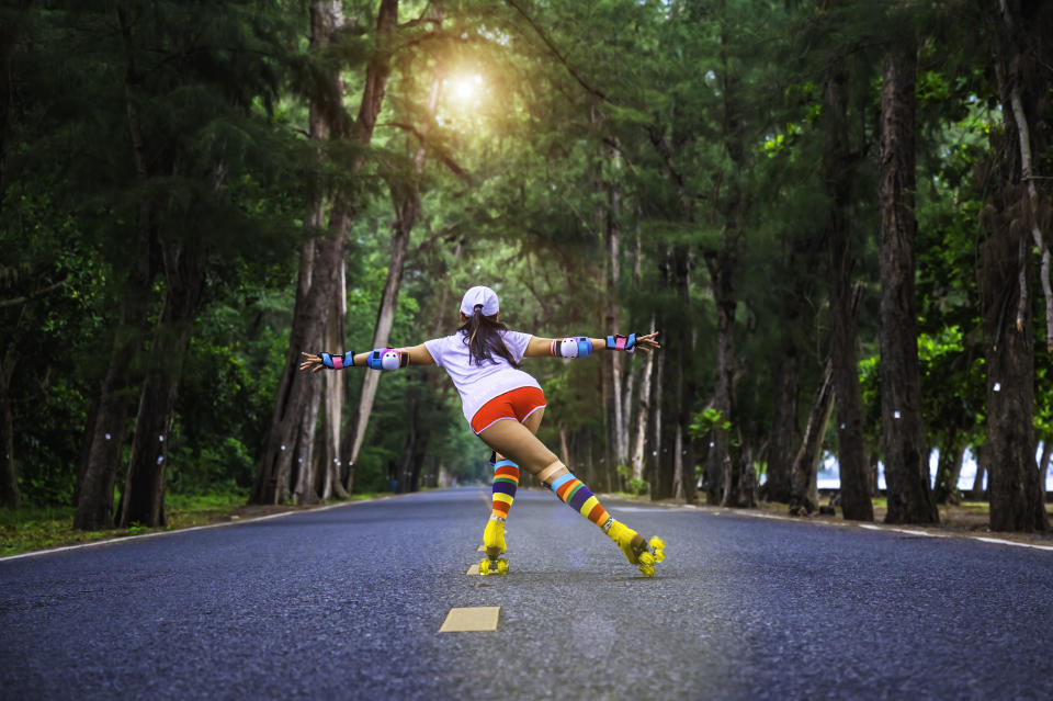 Woman hipster in action of playful joyfully life of rolling skate on speed the roadster in middle of forest at morning light, cheerfully life freedom mind with enjoy the favorite sport personally