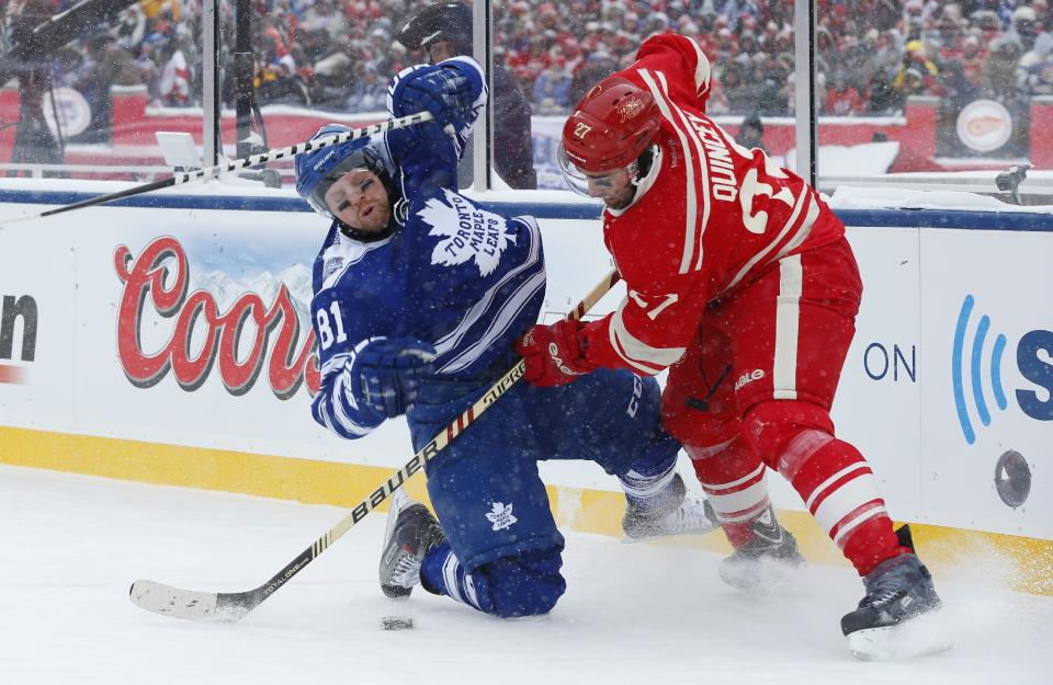 Detroit Red Wings defenseman Kyle Quincey (27) checks Toronto Maple Leafs right wing Phil Kessel (81) during the first period of the Winter Classic outdoor NHL hockey game at Michigan Stadium in Ann Arbor, Mich., Wednesday, Jan. 1, 2014. (AP Photo/Paul Sancya)