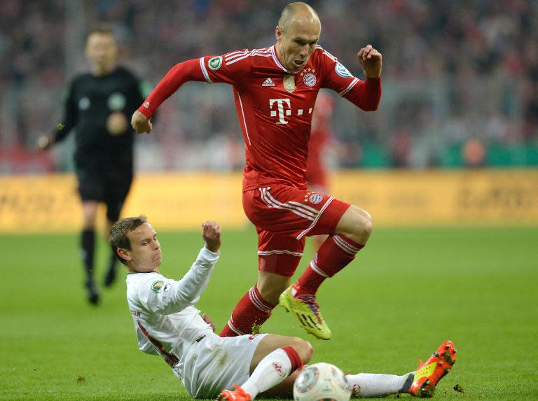 Bayern Munich's Arjen Robben overcomes a challenge from Kaiserslautern's Chris Loewe (L) during the match in Munich on April 16, 2014