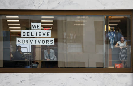 Workers and onlookers watch as activists rally inside the Senate Hart Office Building during a protest in opposition to U.S. Supreme Court nominee Brett Kavanaugh and in support for Christine Blasey Ford, the university professor who has accused Kavanaugh of sexual assault in 1982, on Capitol Hill in Washington, U.S., October 4, 2018. REUTERS/Kevin Lamarque