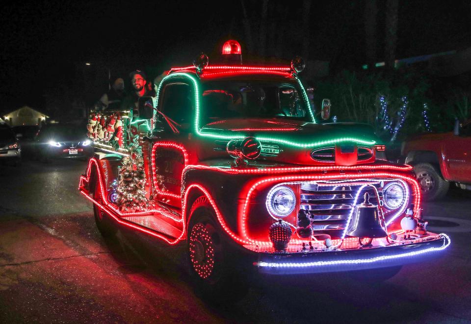 People check out the Christmas decor on Minerva Road from the bed of an old decorated fire truck in Cathedral City, December 15, 2021.