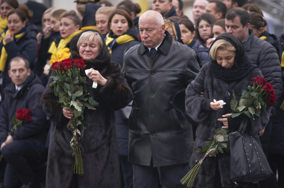 In this photo provided by the Ukrainian Presidential Press Office, relatives of one of the flight crew members of the Ukrainian 737-800 plane that crashed on the outskirts of Tehran, arrive for memorial service at Borispil international airport outside Kyiv, Ukraine, Sunday, Jan. 19, 2020. An Ukrainian passenger jet carrying 176 people has crashed just minutes after taking off from the Iranian capital's main airport on Jan. 8, 2020. (Ukrainian Presidential Press Office via AP)