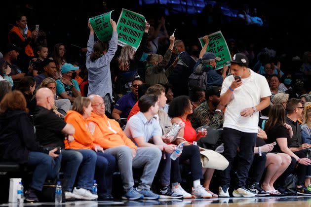 Spectators held up signs while protesters rushed the court in the abortion rights demonstration. (Photo: Sarah Stier via Getty Images)