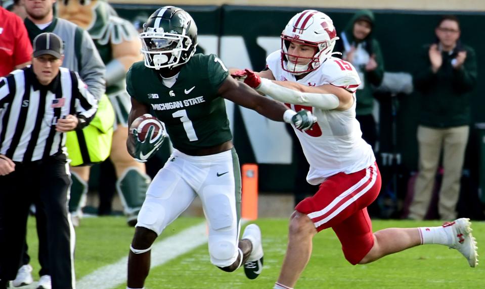 Oct 15, 2022; East Lansing, Michigan, USA; Michigan State Spartans wide receiver Jayden Reed (1) runs down the sideline chased by Wisconsin Badgers safety John Torchio (15) at Spartan Stadium. Mandatory Credit: Dale Young-USA TODAY Sports