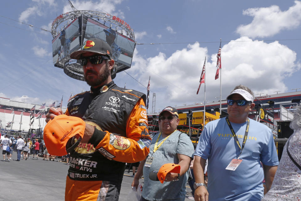 Driver Martin Truex Jr. signs autographs as he walks through the pits before practice for a NASCAR Cup Series auto race, Friday, Aug. 16, 2019, in Bristol, Tenn. (AP Photo/Wade Payne)