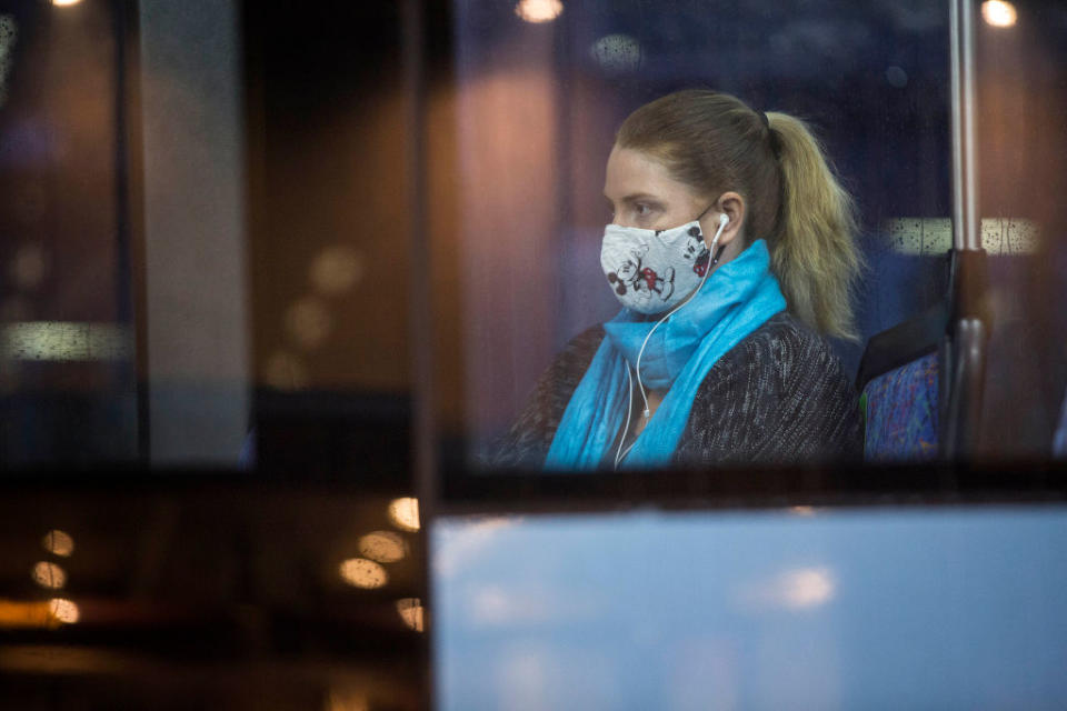 A female passenger wears a face mask while sitting on a bus in Sydney.