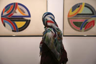 A visitor looks at artworks of the American artist Frank Stella, Sinjerli Variations No. 1-5- 1977, while visiting a 19th and 20th-century American and European minimalist and conceptual masterpieces show at the Tehran Museum of Contemporary Art in Tehran, Iran, Tuesday, Aug. 2, 2022. Some of the world’s most prized works of contemporary Western art have been unveiled for the first time in decades — in Tehran. (AP Photo/Vahid Salemi)