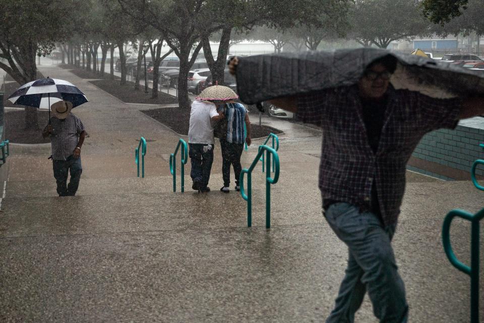 Heavy rain batters people entering and leaving City Hall on Aug. 29, 2022, in Corpus Christi, Texas. 