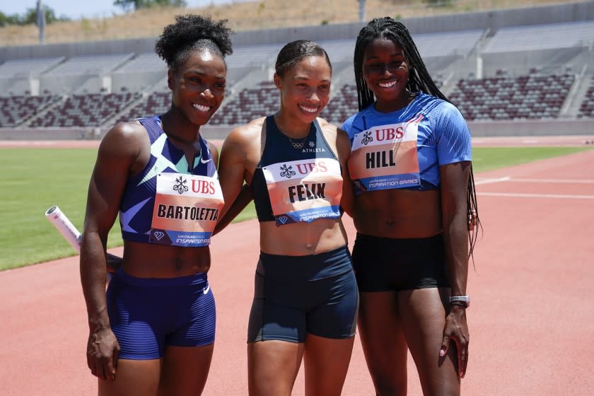 Tianna Bartoletta, left, Allyson Felix, center, and Candace Hill, right, pose for a photo after winning the women's 3x100m.