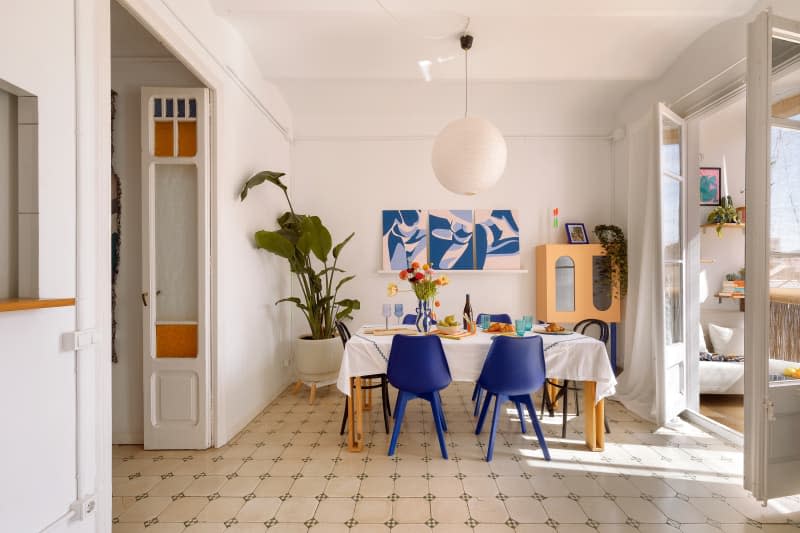 Dining room table with tile floors next to a sunroom.