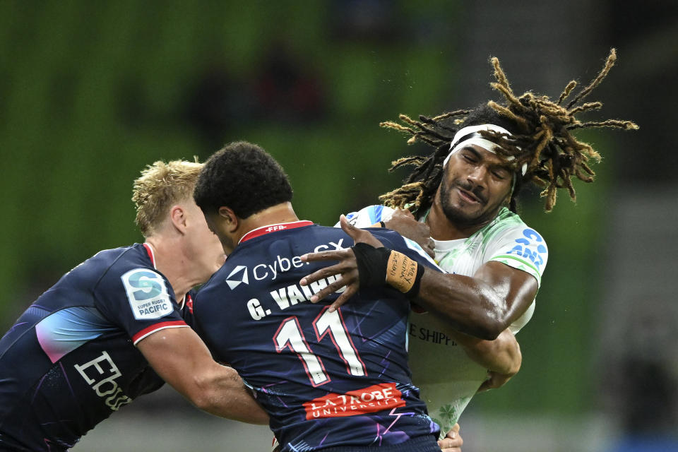 Selestino Ravutaumada of Drua, right, is tackled by Carter Gordon and Glen Vaihu of the Rebels during their Super Rugby Pacific Round 7 match in Melbourne, Friday, April 5, 2024. (James Ross/AAP Image via AP)