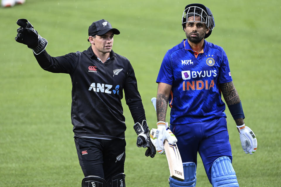 New Zealand's Tom Latham, left, and India's Suryakumar Yadav leave the field for a rain delay during their one day international cricket match in Hamilton, New Zealand, Sunday, Nov. 27, 2022. (Andrew Cornaga/Photosport via AP)