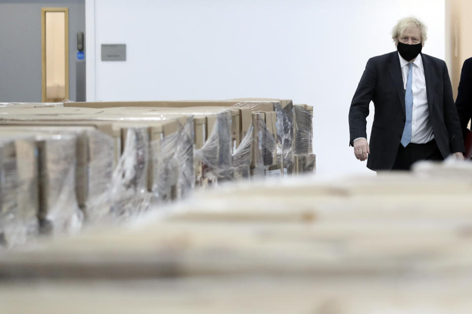 Britain's Prime Minister Boris Johnson, wearing a face mask to prevent the spread of the coronavirus, visits a PPE manufacturing facility during a visit to the north east of England, in Seaton Delaval, England, Saturday, Feb. 13, 2021. (AP Photo/Scott Heppell, Pool)