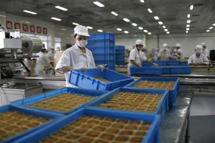 Feshly-baked mooncakes pass along a conveyor belt at a factory in Shanghai.