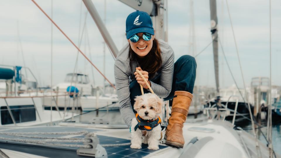 A woman on a boat with a dog.