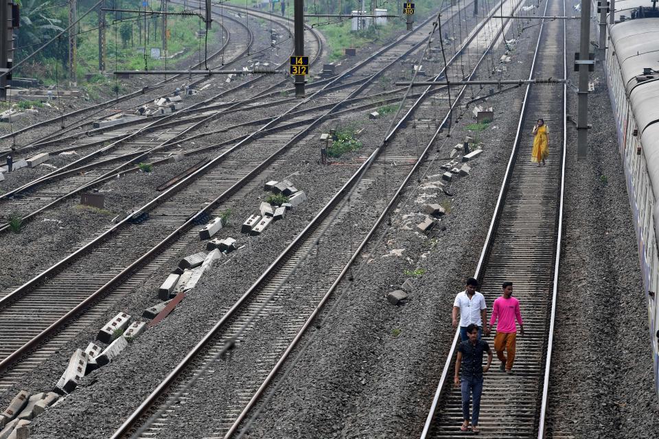 Passengers walk on a railway track after trains got stranded due to a major power cut in several areas after grid failure in Mumbai on October 12, 2020. (Photo by INDRANIL MUKHERJEE / AFP) (Photo by INDRANIL MUKHERJEE/AFP via Getty Images)