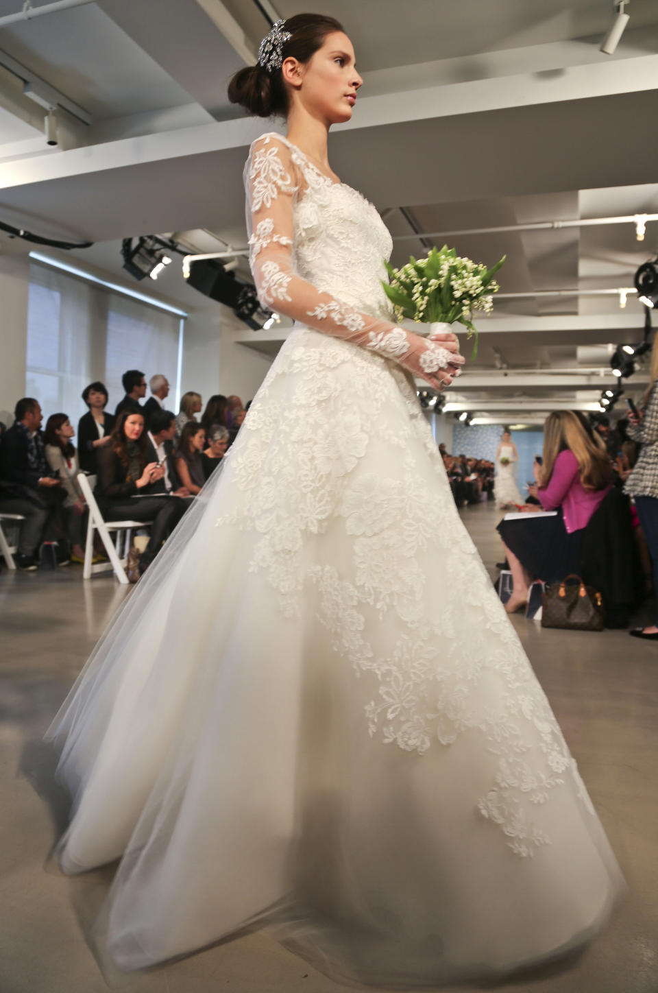 A model presents a bridal fashion creation from the Oscar de la Renta collection, in New York, Monday, April 22, 2013. (AP Photo/Bebeto Matthews)