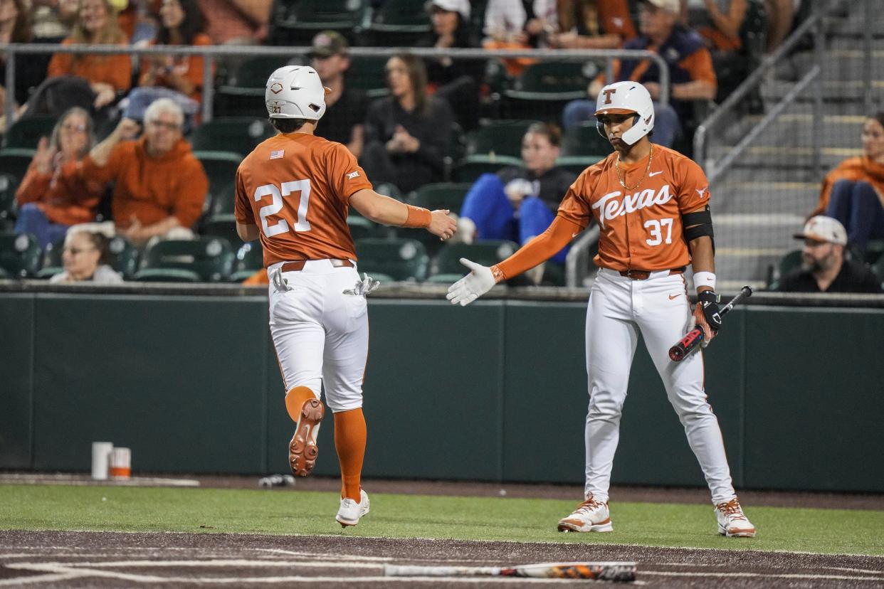 Texas infielder Jack O'Dowd (27) high fives Texas catcher Nik Sanders (37) after running home as the Longhorns play Houston Christian at UFCU Disch–Falk Field on Tuesday, Feb. 20, 2024.