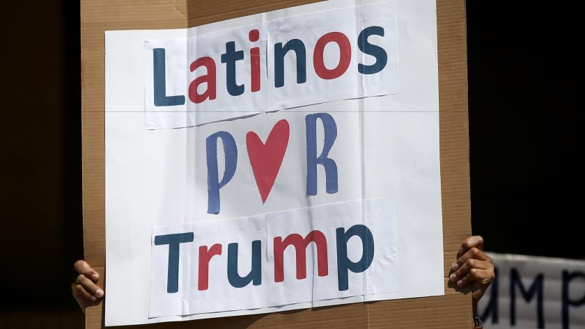 A man hoists a sign during a rally of about 100 of presidential candidate Donald Trump's Latino supporters outside Anaheim City Hall on Aug. 28.