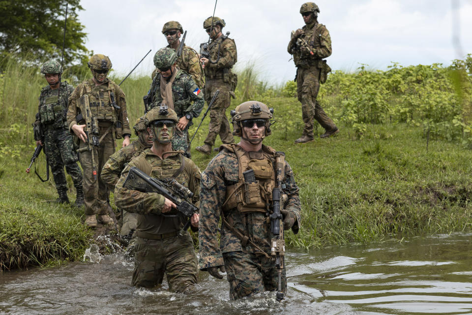 In this photo released by Australian Department of Defense via Australian Embassy in the Philippines, a Commanding Officer of the 1st Battalion, the Royal Australian Regiment Lieutenant Colonel Brent Hughes (center) moves across a waterway with United States Marines and Armed Forces of the Philippines soldiers during a large-scale combined amphibious assault exercise on Friday, Aug. 25, 2023, at a naval base in San Antonio, Zambales, Philippines. The Philippines and Australia, while also backed by the United States Marine Corps, are holding a bilateral amphibious training called "Exercise Alon 2023," coined from Tagalog word meaning "wave," which is aimed at enhancing interoperability and preparedness to respond to security challenges in the Indo-Pacific region. (Riley Blennerhassett/Australian Department of Defense via AP)