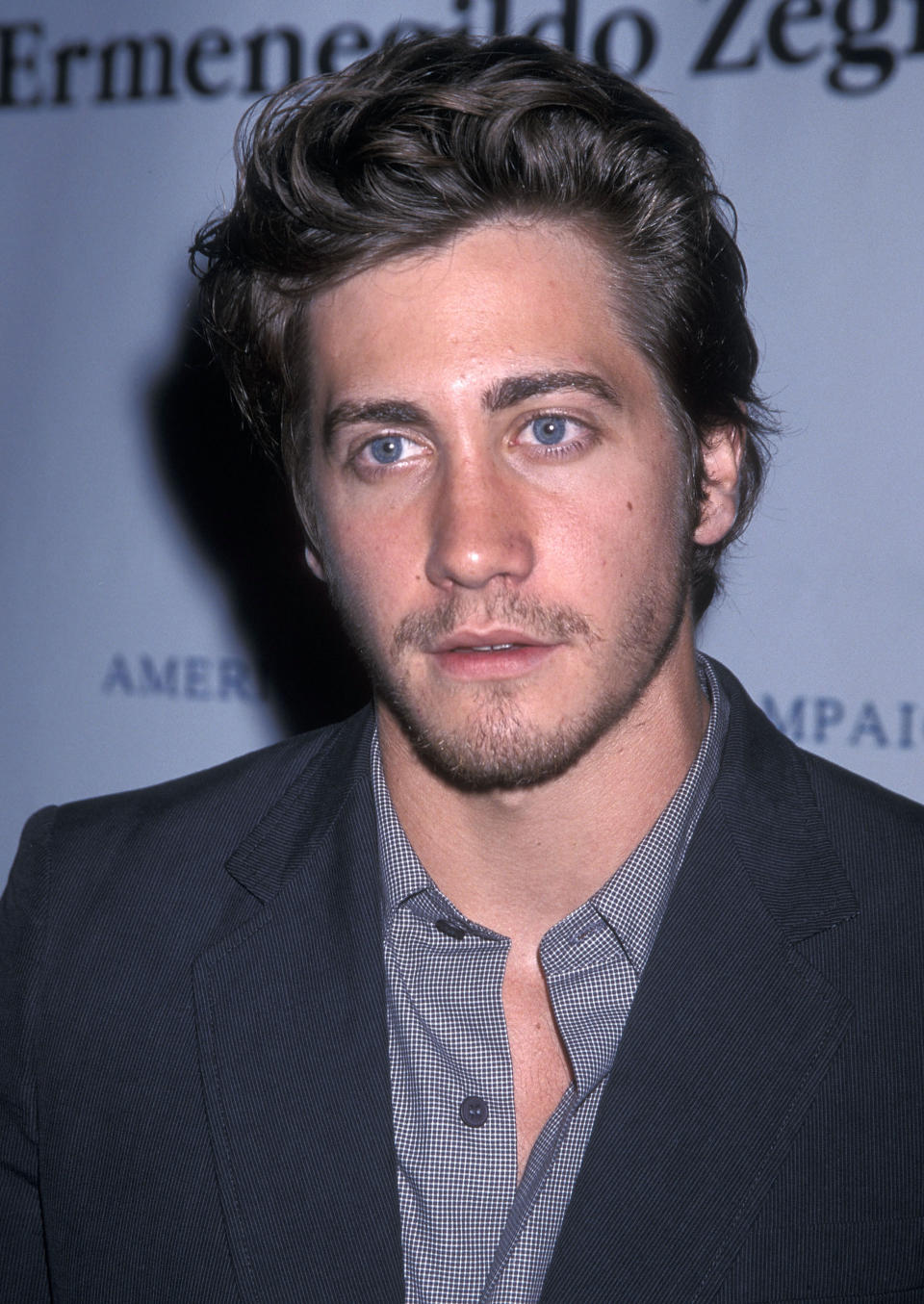 A younger Jake posing at an event, wearing a suit jacket and patterned shirt