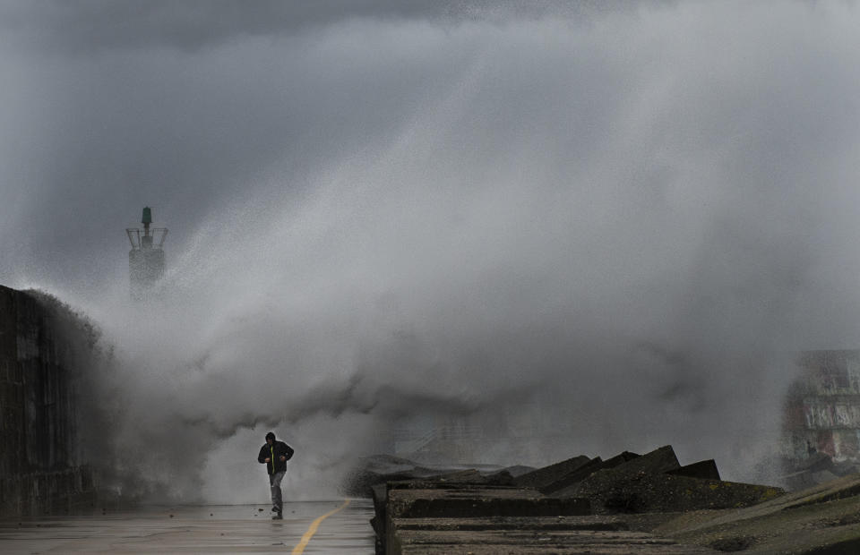 A man runs as a big wave hits the pier of the port of A Guarda&nbsp;in northwestern Spain during a storm on&nbsp;Feb. 2, 2017.