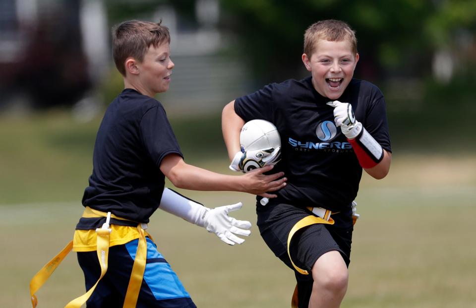 Kyle Tufnell, right, and Chandler Maney, both 10, goof around during a Howard-Suamico Youth Flag Football practice on Friday at Idlewild Park in Suamico before the NFL FLAG Football regional tournament at the Green Bay Packers' Ray Nitschke Field.