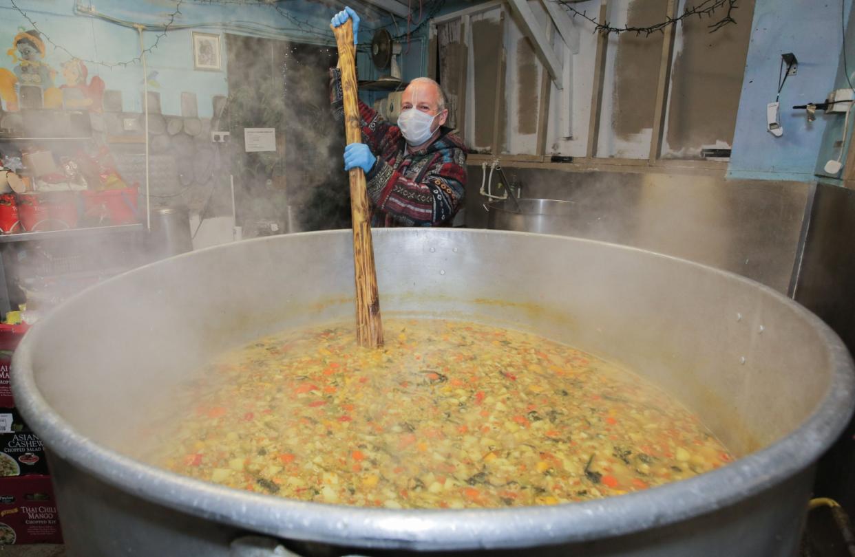 Cooking For Haringey with Para stirring the giant cooking pot containing a vegetable curry dish with a boating oar at their headquarters in the City of London: Matt Writtle