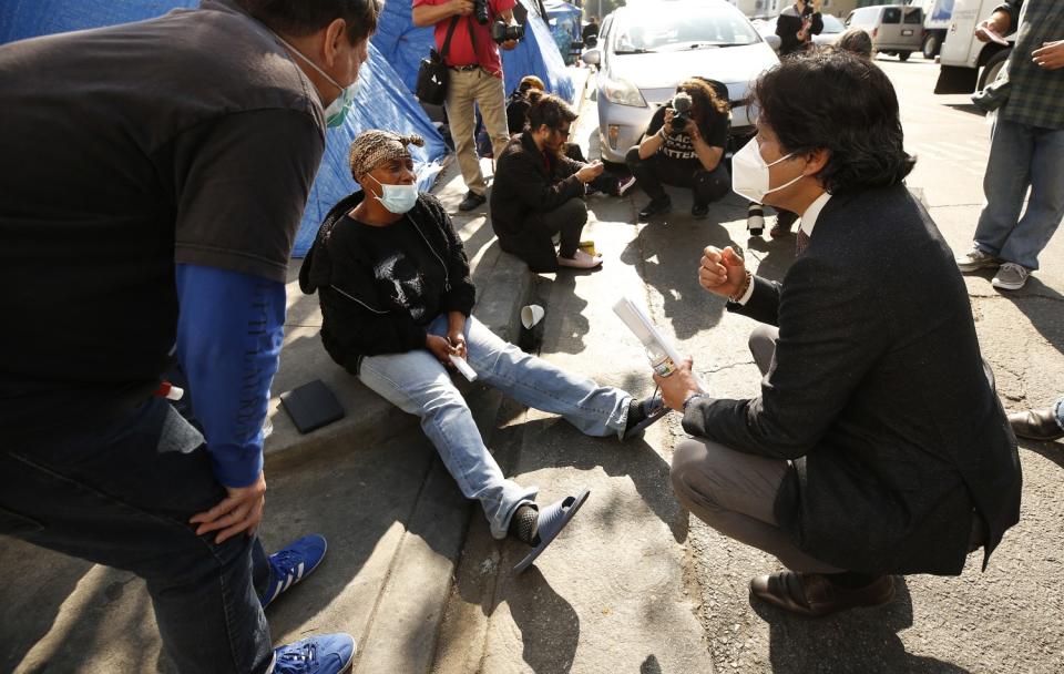 A councilman talks to a homeless woman