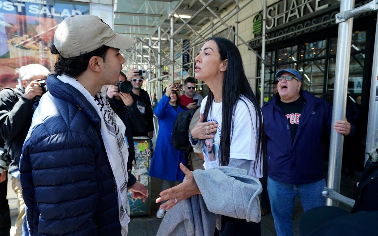 A pro-Palestinian supporter and and supporter of Israel argue with each other on the sidewalk