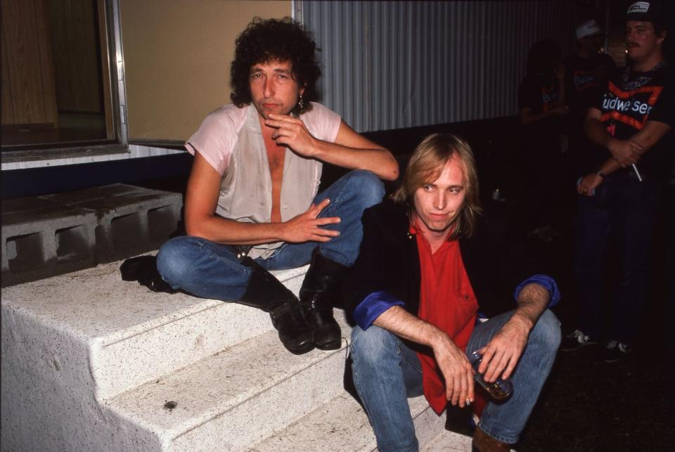 <p>Musicians Bob Dylan and Tom Petty sit on the steps of their trailer at the 1985 Farm Aid concert in Chicago. Both musicians produced some of music's all-time greatest hits. </p>