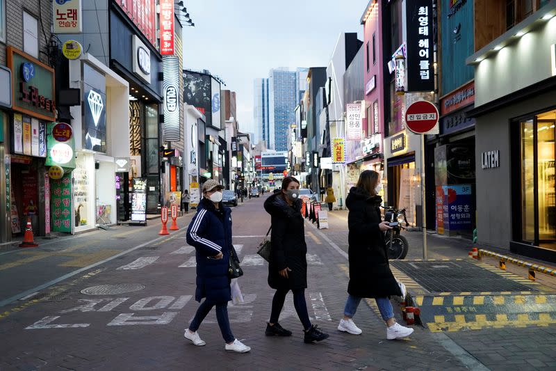 Women wearing masks to prevent contracting the coronavirus walk at Dongseong-ro shopping street in central Daegu