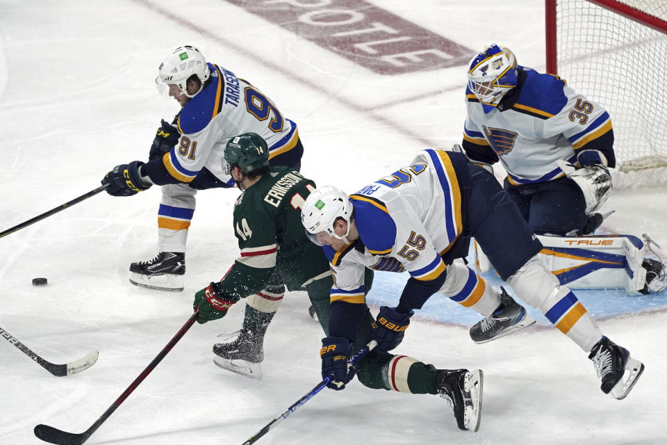 Minnesota Wild's Joel Eriksson Ek (14) races for the puck as St. Louis Blues' Vladimir Tarasenko (91) and goalie Ville Husso (35) defend , while Colton Parayko (55) trips during the second period of Game 2 of an NHL hockey Stanley Cup first-round playoff series Wednesday, May 4, 2022, in St. Paul, Minn. (AP Photo/Jim Mone)