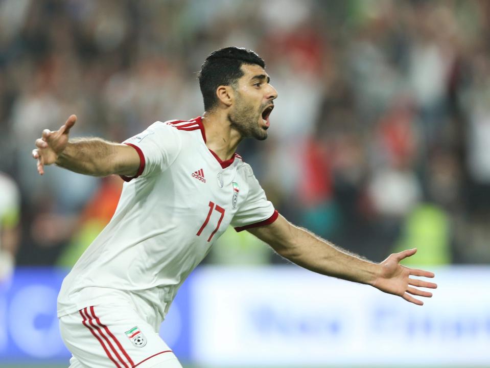 Mehdi Taremi runs and yells as he celebrates during an Iran soccer match.