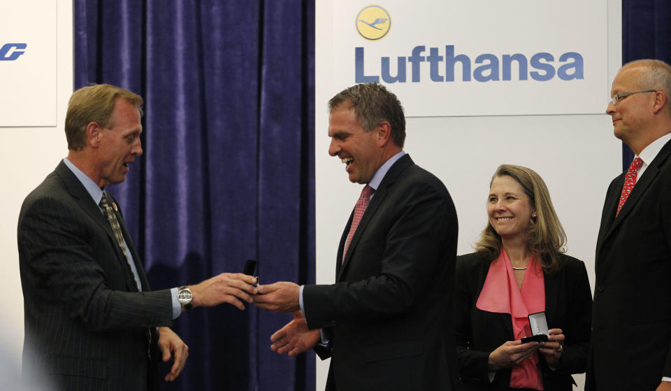 Boeing senior vice president Pat Shanahan, left, hands over the keys to a new Boeing 747-8 Intercontinental plane to Lufthansa CEO Carsten Spohr as Boeing vice president and 747 program general manager Elizabeth Lund, second right, and Lufthansa executive vice president Nico Buchholz look on Tuesday, May 1, 2012, in Everett, Wash. Lufthansa is the launch customer for the Intercontinental and will start service with the airplane between Frankfurt, Germany and Washington, D.C. The 747-8 Intercontinental is a stretched, updated version of the iconic 747 and is expected to bring double-digit improvements in fuel burn and emissions over its predecessor, the 747-400, and generate 30 percent less noise. Boeing delivered the first 747-8 Intercontinental to a private customer in February, more than a year after originally planned. (AP Photo/Elaine Thompson)