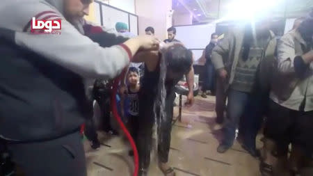 A man is washed following alleged chemical weapons attack, in what is said to be Douma, Syria in this still image from video obtained by Reuters on April 8, 2018. White Helmets/Reuters TV via REUTERS