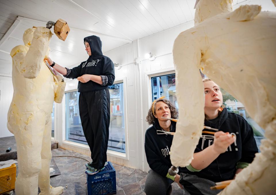 Grace Pratt, left, works on a sculpture of quarterback Kurt Warner while Hannah and her mother, Sarah Pratt, look over the lettering on Caitlin Clark's jersey.
