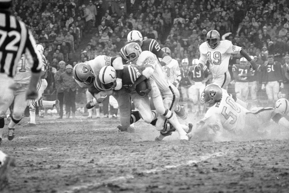 FILE - Baltimore Colts running back Norm Bulaich is hauled down by Oakland Raiders defenders Drew Buie (89) and Gerald Irons (86) during the AFC NFL football championship game at Memorial Stadium in Baltimore, Jan. 3, 1971. For the first time in 53 years, Baltimore is hosting the AFC championship game, bringing a different kind of spotlight to Charm City this weekend. (AP Photo/File)