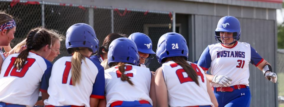 Tuslaw's Camryn Kiefer is about to be mobbed at home plate after ripping a fourth inning three-run blast to make it 11-0 in Div. III District Final action.