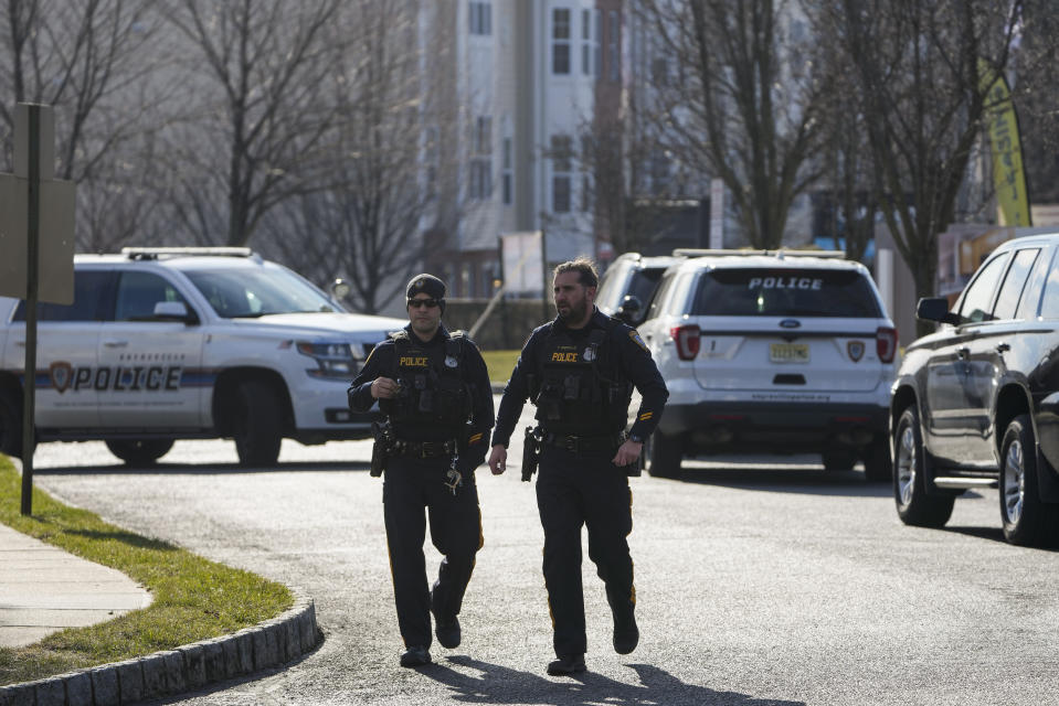 CORRECTS TO THE PARLIN AREA OF SAYREVILLE - Police officers investigate a wooded area near a townhome community, Thursday, Feb. 2, 2023, in the Parlin area of Sayreville, N.J., where Sayreville councilwoman Eunice Dwumfour was found shot to death in an SUV parked outside her home on Wednesday. According to the Middlesex County prosecutor's office, she had been shot multiple times and was pronounced dead at the scene. (AP Photo/Seth Wenig)