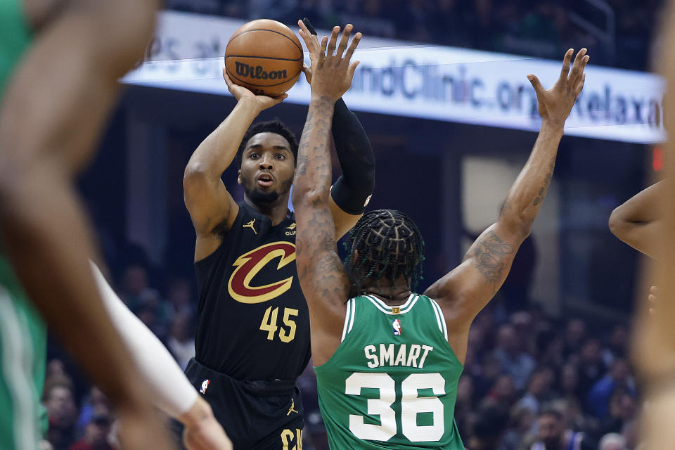 Cleveland Cavaliers guard Donovan Mitchell (45) shoots a 3-point basket against Boston Celtics guard Marcus Smart (36) during the first half of an NBA basketball game, Monday, March 6, 2023, in Cleveland. (AP Photo/Ron Schwane)